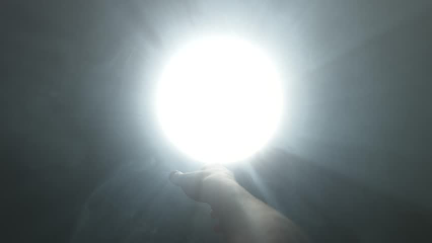 Hand Reaching Toward Divine Light in Darkness
