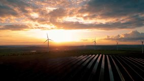 Solar panels park and wind turbines at sunset.Windmill turbines generating green energy electric.Green energy reduce carbon emissions and makes earth cleaner and more ecological. - Powered by Shutterstock - Get 15% off with code: PIKWIZARD15