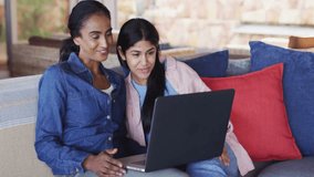 mother and daughter opening laptop in tech demo causing floating emojis around screen disappearing. Family, bonding, communication, leisure, vibrant, multicultural, casual - Powered by Shutterstock - Get 15% off with code: PIKWIZARD15
