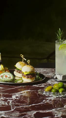 Tasty Slider Burgers on a Marble Table with Refreshing Drink – Gourmet Mini Burgers and Beverage in Restaurant Setting in 4K Ultra HD