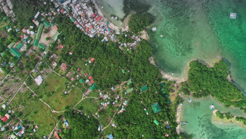 Stunning aerial drone footage captures the idyllic beauty of Malapascua Island in the Philippines, showcasing the vibrant coastline, traditional outrigger boats, and lush tropical vegetation