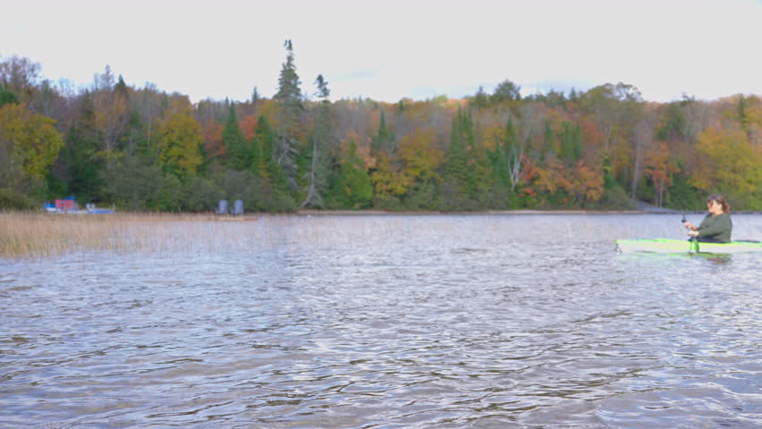 Kayaking on a tranquil lake surrounded by autumn colors