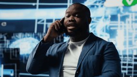 Black entrepreneur using mobile phone call to interact with people, shares insight on cybernetic platforms and AI interfaces. Machine learning and predictive analytics for growth. Camera A. - Powered by Shutterstock - Get 15% off with code: PIKWIZARD15