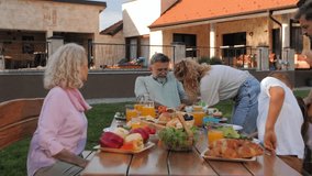 Family members gathering for outdoor lunch, enjoying shared meal while creating cherished moments across generations under warm sunlight - Powered by Shutterstock - Get 15% off with code: PIKWIZARD15