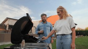 Happy couple preparing barbecue in their backyard, grilling meat and having fun on a sunny day - Powered by Shutterstock - Get 15% off with code: PIKWIZARD15