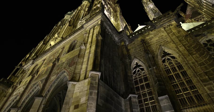 Prague St. Vitus Cathedral gothic church building detailed view at night illuminated in the dark, dramatic tall towers with gargoyles and sculptures