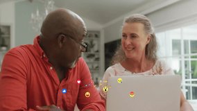Senior couple checking social feed via laptop screen starting floating reaction emojis across frame. Connection, teamwork, communication, lifestyle, technology, warmth, positivity - Powered by Shutterstock - Get 15% off with code: PIKWIZARD15