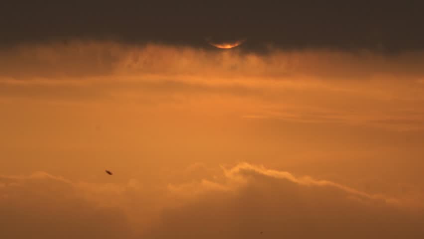 Time lapse of dramatic sunset with orange sky in a cloudy day