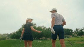 Couple walks up to the tee box together, laughing and chatting with drivers in hand. The scene captures a joyful, candid moment between partners during a relaxed round on a scenic course. - Powered by Shutterstock - Get 15% off with code: PIKWIZARD15