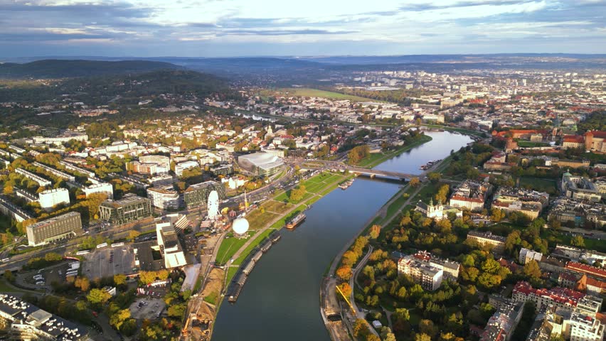 High angle footage of a warm surnise morning in the beautiful city of Krakow in Poland. Canals, bridges over the  Vistula river seen from above during a misty sunrise. Establishing shot in a city.