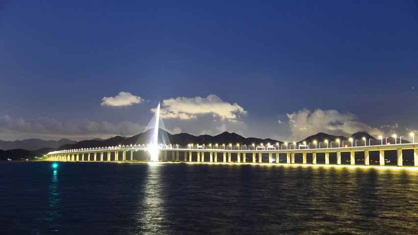 Experience the beauty of Shenzhen Bay Highway Bridge as it lights up the night sky. The bridge connects Hong Kong to mainland China, showcasing stunning architecture and scenic views.