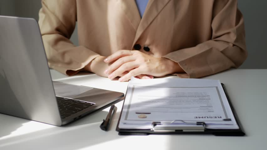 Young businesswoman holds a resume and evaluates it. Views the personal history of job applicants. Recruitment concept.