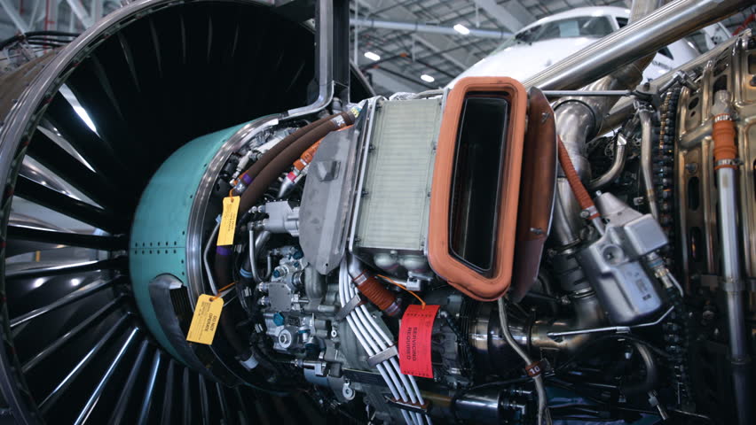Engineers Working on a jet engine in an airplane hangar