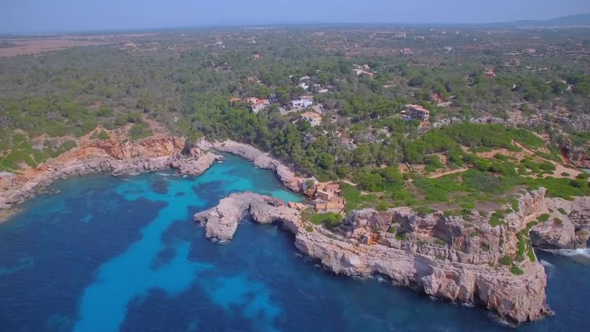 Aerial view of a rocky coast meeting the turquoise sea in mallorca