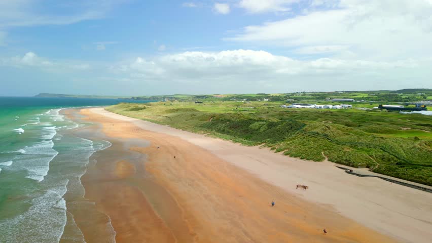 Ultra-wide aerial video of East Strand beach in Portrush, Northern Ireland on a bright and sunny day. Filmed in 4K, 60 frames per second and with Rec709 color.