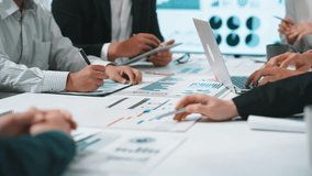 A diverse business team engages in a collaborative financial analysis, surrounded by charts and digital devices while strategizing in a modern office setting. SACTR - Powered by Shutterstock - Get 15% off with code: PIKWIZARD15