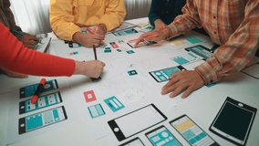 A diverse team engages in a dynamic design session for mobile app development, showcasing sketches and prototypes on a collaborative workspace filled with creativity. SACTR - Powered by Shutterstock - Get 15% off with code: PIKWIZARD15