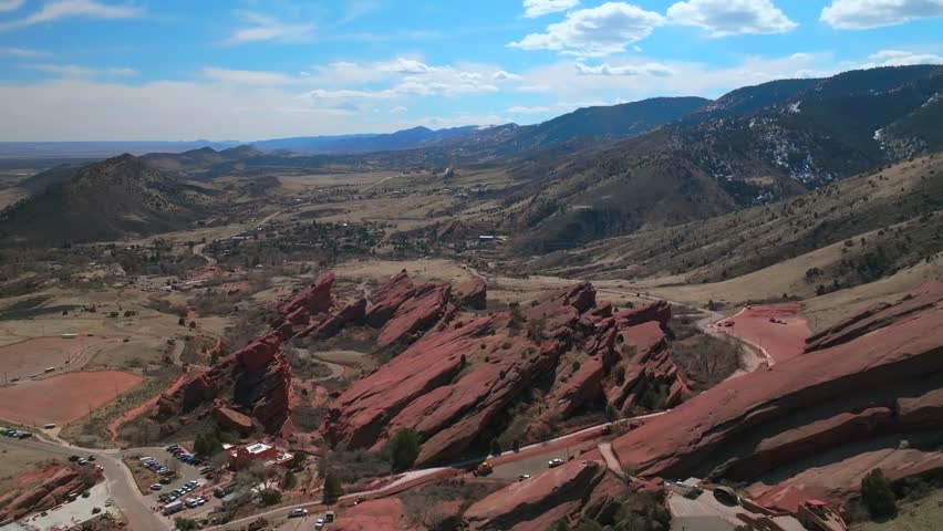 Red Rocks Park and Amphitheater Mount Morrison Colorado aerial drone large sandstone features mid winter windy roads walking trails Trading Post sunny blue sky clouds parking lot cars forward pan up