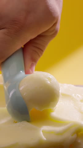 Ice cream scooping. Scoop lemon or pineapple sorbet. Vertical close-up