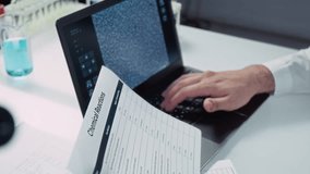 Arc close-up of two multiethnic postgraduate students performing experiment in laboratory, Chinese woman in face mask peering at sample into microscope, Arab male colleague typing in results on laptop - Powered by Shutterstock - Get 15% off with code: PIKWIZARD15