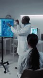 Full vertical shot of mature Black male professor conducting seminar for bioengineering students on DNA structure and genetics, female listener raising hand, teacher answering and explaining - Powered by Shutterstock - Get 15% off with code: PIKWIZARD15
