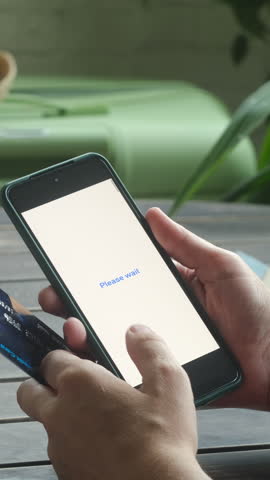 Vertical video. Person paying online using smartphone and bank credit card. Payment received text on phone screen. 