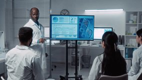 Medium full shot of senior African American male professor in white coat talking about DNA therapy to group of multiethnic university students in research laboratory, demonstrating simulation model - Powered by Shutterstock - Get 15% off with code: PIKWIZARD15