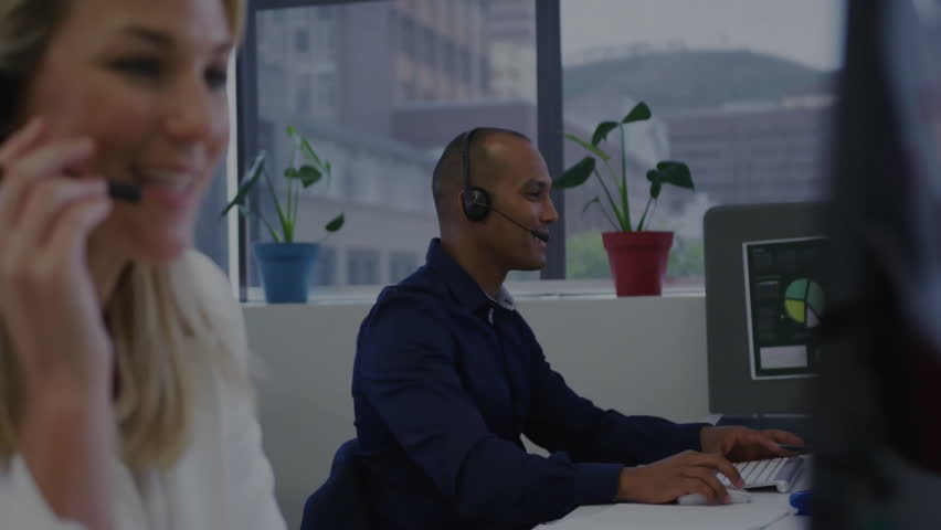 Two agents lifting headset mic and typing while rotating hologram globe enabling customer service. Professional, teamwork, technology, communication, analytics, office, urban - Powered by Shutterstock - Get 15% off with code: PIKWIZARD15