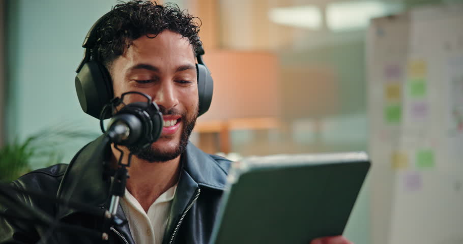 Tablet, presenter and man with mic in studio for podcast, broadcast or interview with online questions. Content creation, talking and person with digital tech for hosting, radio show and recording