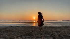 A girl dances, stretches, and moves gracefully on the beach at sunrise. Silhouetted against the rising sun, she creates a serene and expressive morning scene by the sea.
 - Powered by Shutterstock - Get 15% off with code: PIKWIZARD15