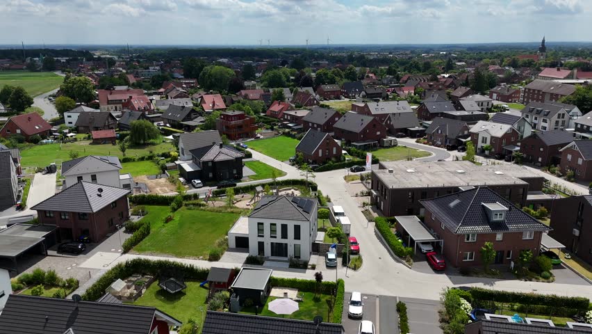 Luxury villas and single family homes during sunny day in America. Aerial orbit shot. Wide shot. Farm fields in distance. Two-story urban houses in new developed area of american town.