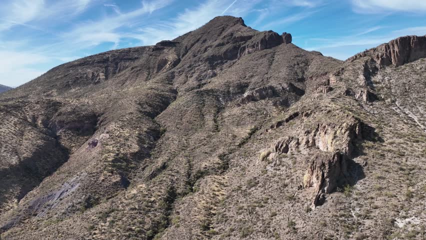 Aerial view of a rugged mountain landscape bathed in sunlight, with deep shadows accentuating the textures, Cave Creek, Arizona, United States.