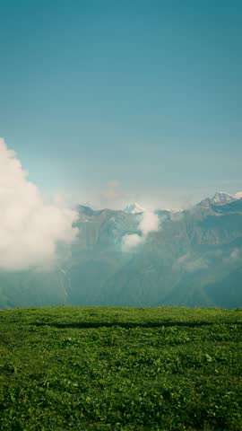 A man walks along the top of a green mountain at Buda Madmaheshwar, Rudraprayag, Uttarakhand, India, gazing out at the horizon, completely lost in the view.