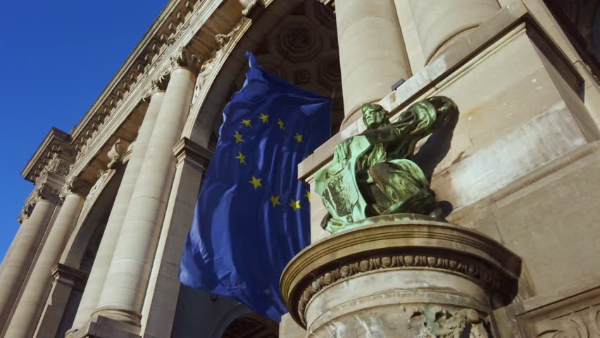 EU flag waving on neoclassical building in Brussels, Belgium