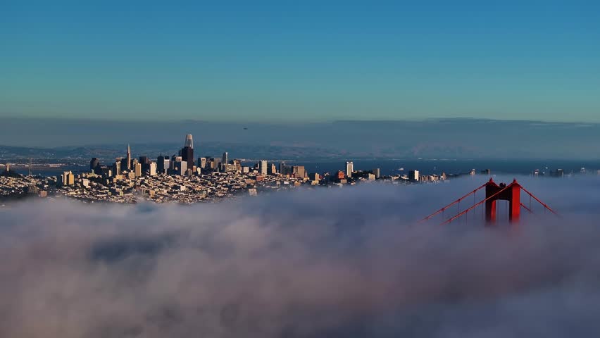 Aerial view of the Golden Gate Bridge piercing through a sea of fog with the San Francisco skyline in the background, San Francisco, California, United States.