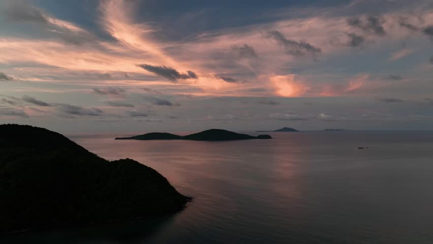 Aerial view of islands at dusk, the water reflecting the pink sky, creating a serene and tranquil scene of nature