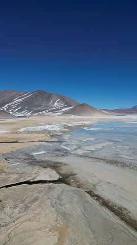 Aerial View of a stark landscape where the desert floor blends into the rugged horizon, a symphony of muted tones, San Pedro de Atacama, Antofagasta, Chile.