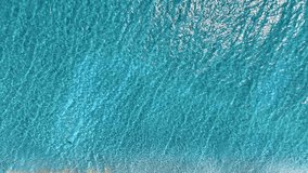 Aerial view of sea surface with reflected sunlight. Turquoise water ripples background texture on sea coast. Mediterranean waves on bright sunny day. Water landscape. - Powered by Shutterstock - Get 15% off with code: PIKWIZARD15