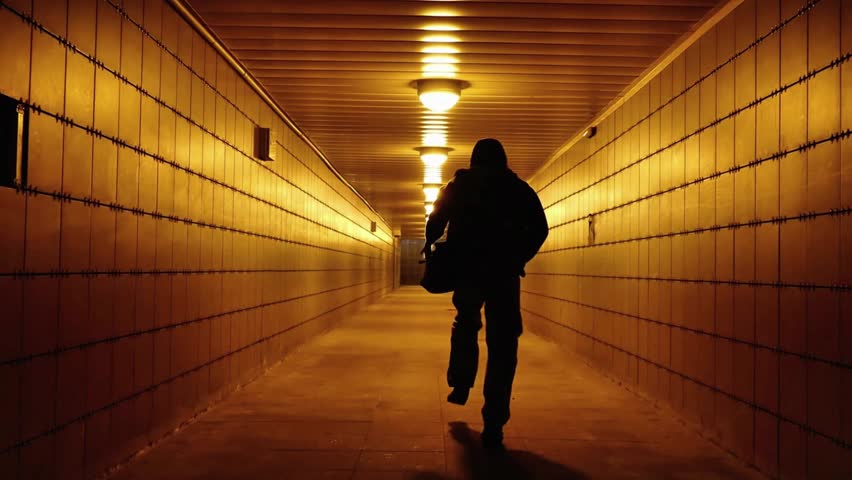 A man walks through a pedestrian crossing tunnel, a dark silhouette, looking for an exit. City communications of the big city of Saint Petersburg, Russia, July 5, 2024