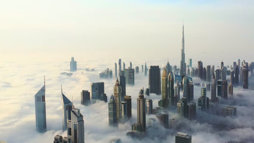Aerial view of Dubai skyline covered in dense fog during sunrise