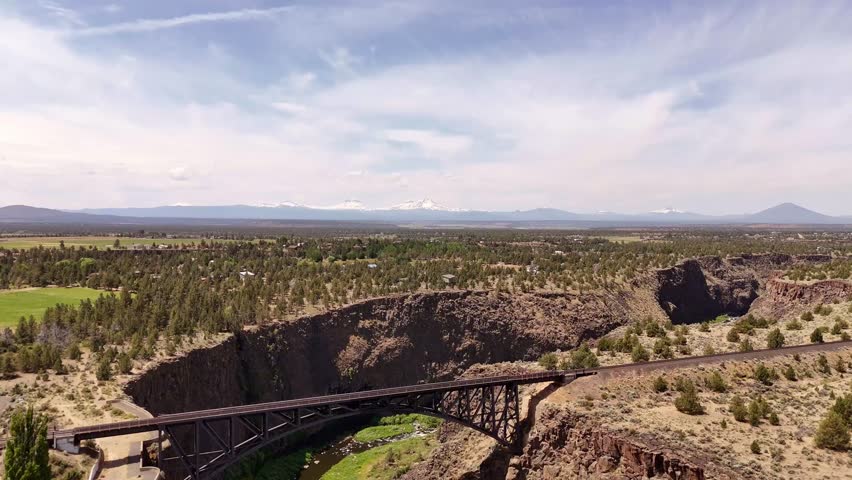 Aerial view of the bridge over a canyon, contrasting the green of the river with the brown of the rocks, Peter Skene Ogden, Terrebonne, United States.