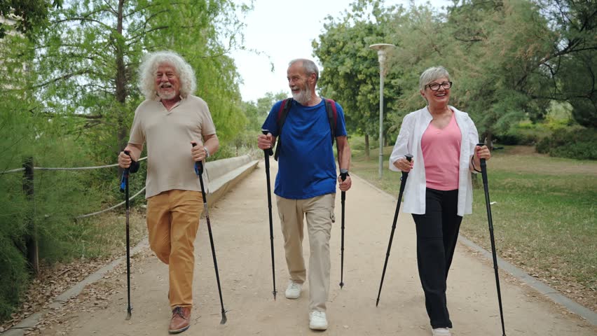 Three Senior friends practicing sport, hiking for fitness and leisure in the city park. Active retired people