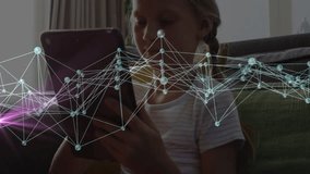 Girl tapping tablet screen and swiping, generating technology network overlay pulsing across sofa. Children, digital, connectivity, technology, home, innovation, education - Powered by Shutterstock - Get 15% off with code: PIKWIZARD15