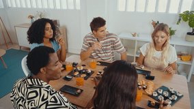 Group of friends enjoys a shared sushi meal, laughing and feeding each other in a cozy home setting, capturing moments of fun and friendship - Powered by Shutterstock - Get 15% off with code: PIKWIZARD15