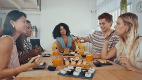Group of friends enjoys a shared sushi meal, laughing and feeding each other in a cozy home setting, capturing moments of fun and friendship - Powered by Shutterstock - Get 15% off with code: PIKWIZARD15