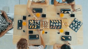 Group of friends enjoys a shared sushi meal, laughing and feeding each other in a cozy home setting, capturing moments of fun and friendship - Powered by Shutterstock - Get 15% off with code: PIKWIZARD15