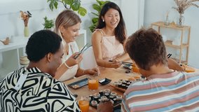 Group of friends enjoys a shared sushi meal, laughing and feeding each other in a cozy home setting, capturing moments of fun and friendship - Powered by Shutterstock - Get 15% off with code: PIKWIZARD15