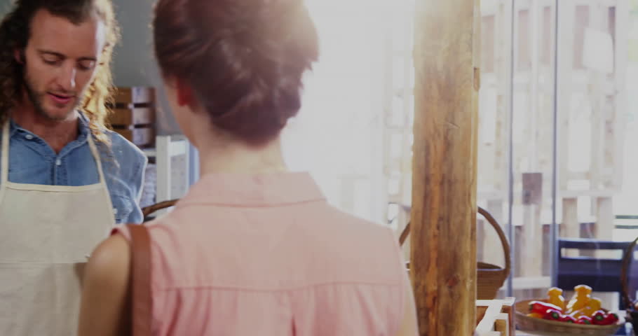 Market vendor selecting yellow pepper for shopper and bagging with animated overlay closing bag. Market, farmer, artisan, rustic, freshness, organic, shopping