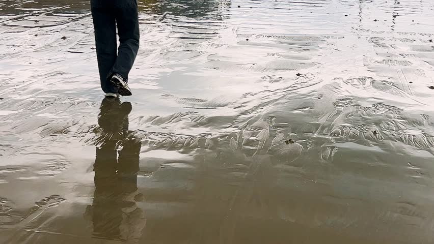 Walking on wet sandy beach on the English Channel at low tide in Saint-Malo. Grande Plage du Sillon. Saint-Malo, Ille-et-Vilaine, Brittany, France.
