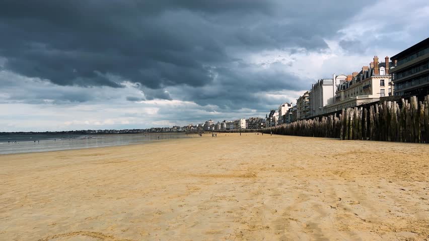 View of the sandy beach of Plage de l’Eventail, English Channel under a stormy sky in Saint Malo, Brittany, France.